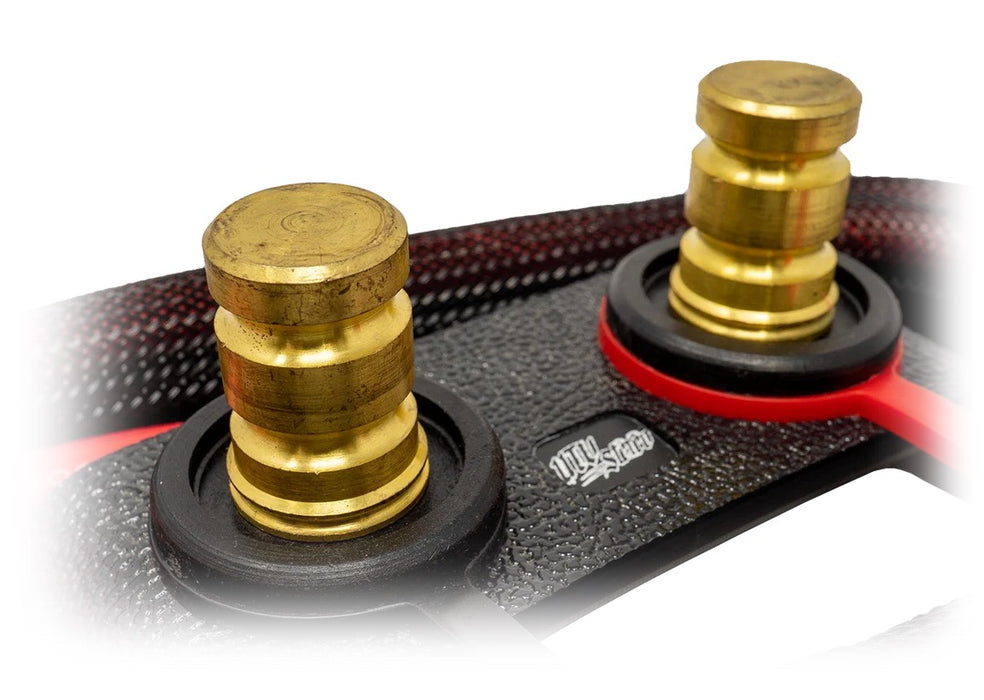 Close-up of a black textured RC drone body with two gold metal motor mounts, black rubber rings, and red accent rings.